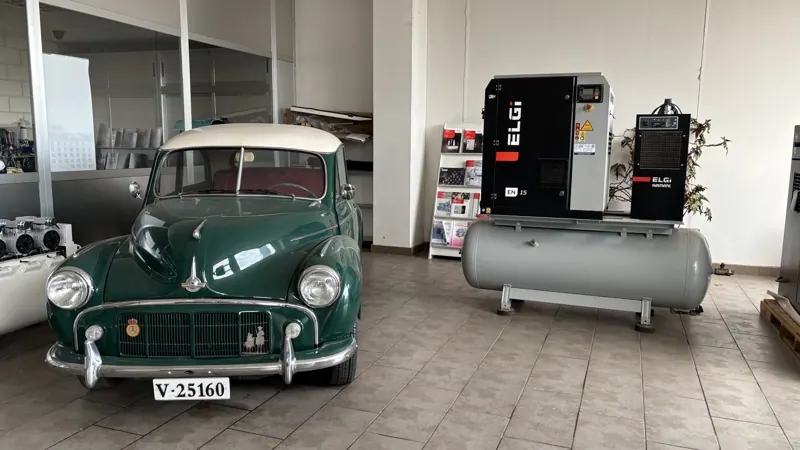 Compresor ELGi con calderín junto a un coche clásico restaurado en la exposición de Grupo JOH